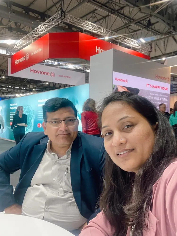 Two colleagues at an exhibition stand during a networking conversation