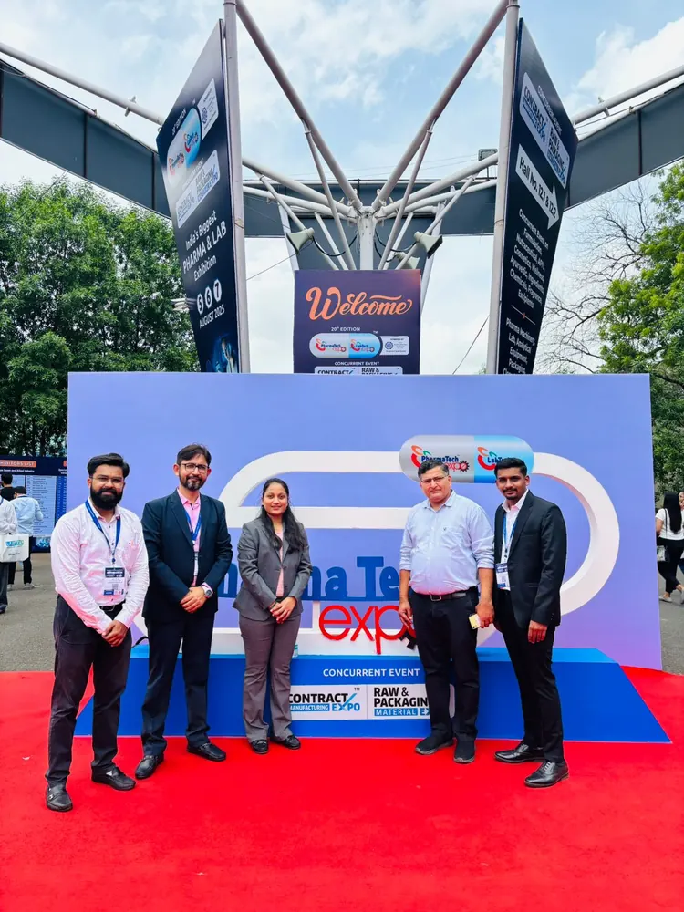 PharmExpert colleagues on the red carpet in front of an exhibition welcome stage