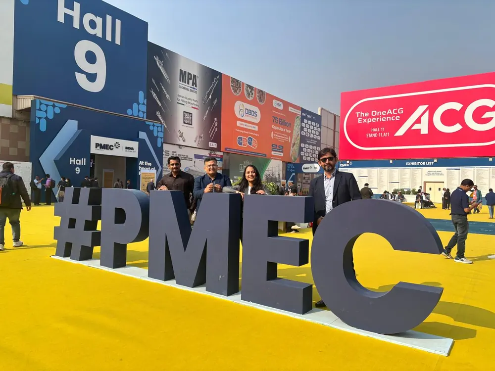 PharmExpert colleagues at the PMEC India exhibition signage